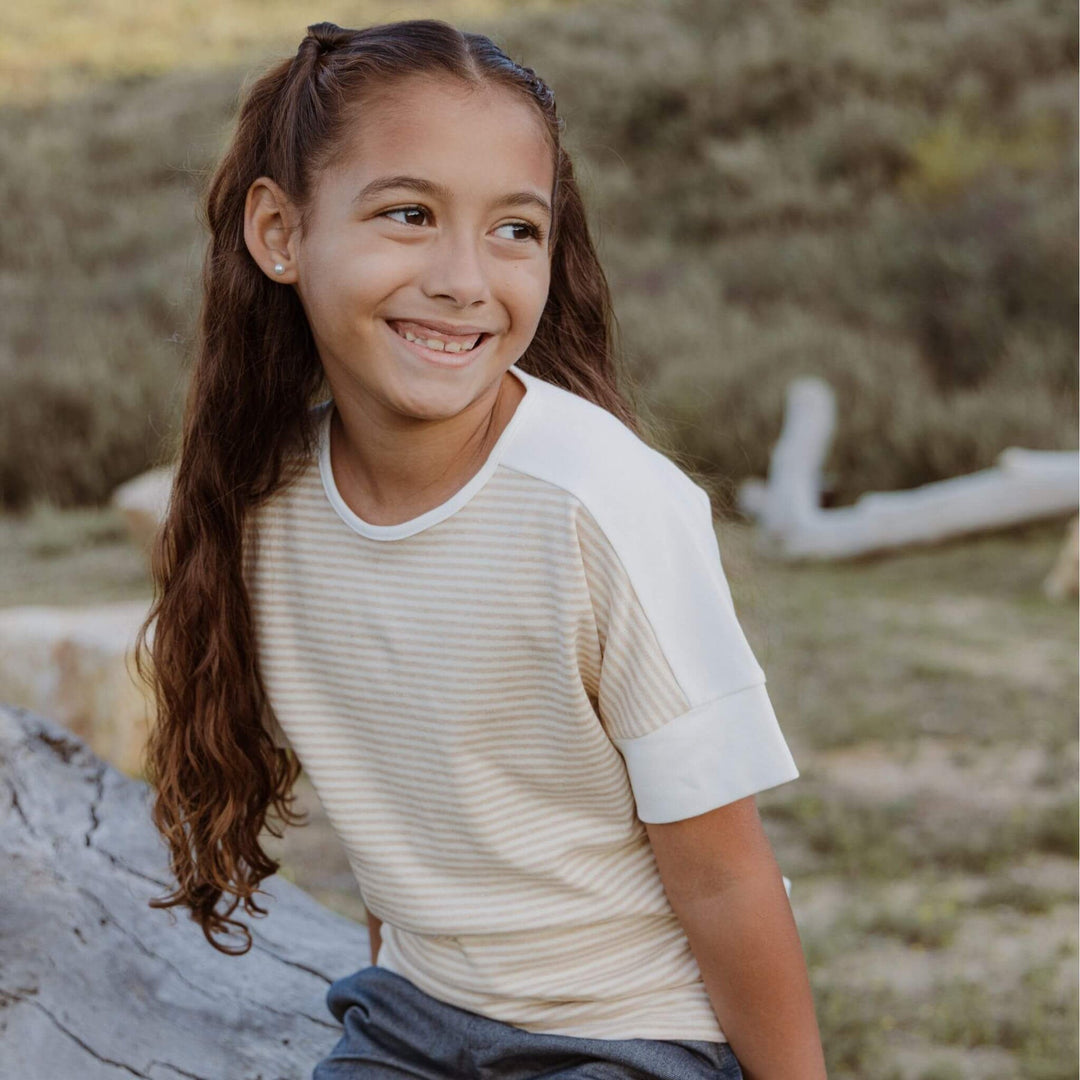 Young girl in striped shirt from Firebird Kids smiling outdoors