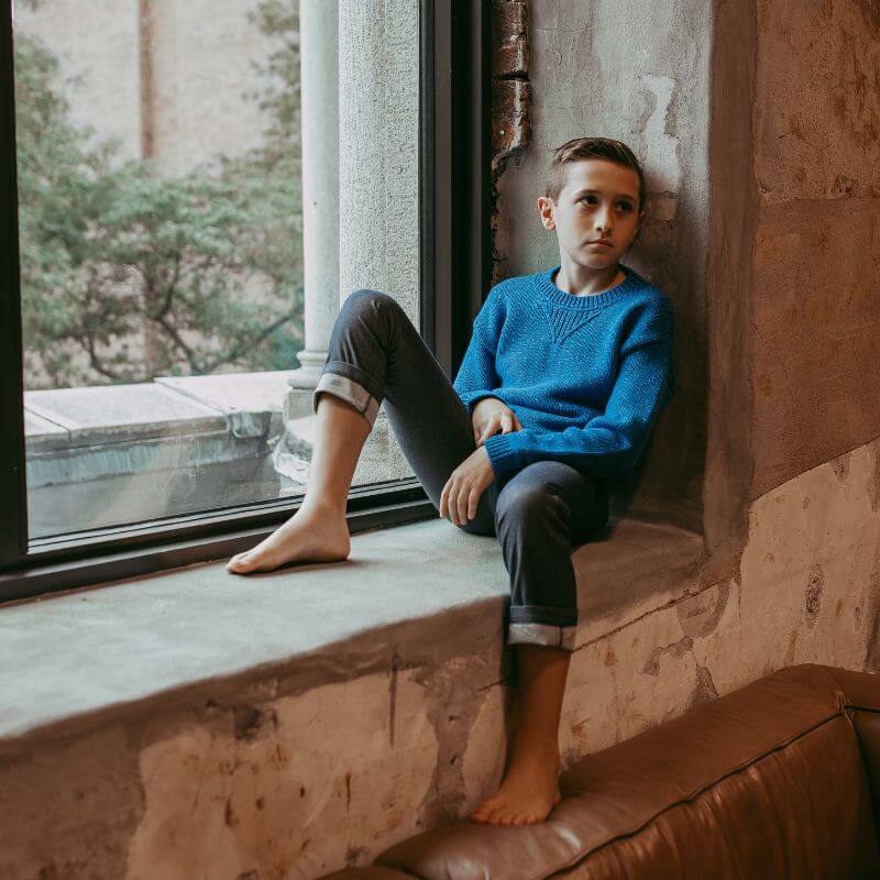 Boy wearing a blue knit organic sweater by Firebird Kids