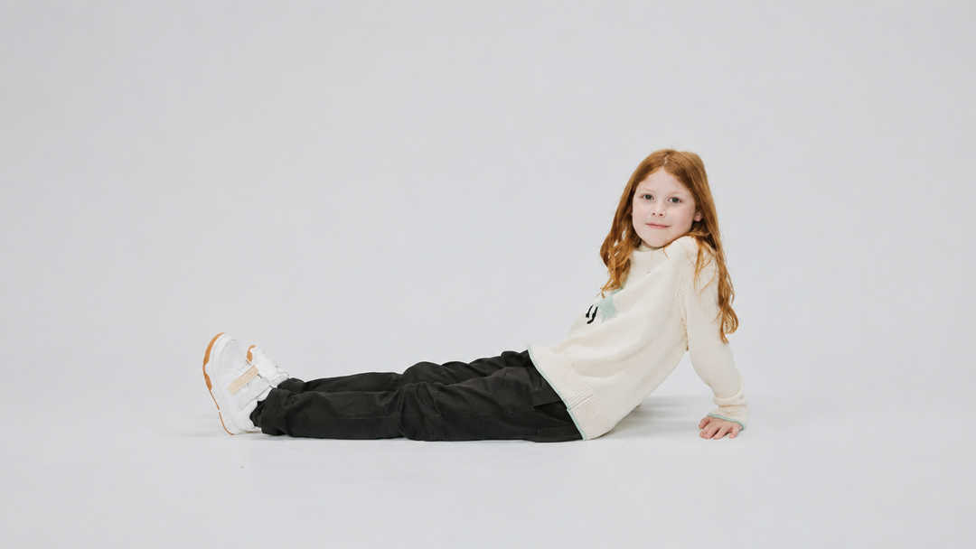 Kid in a Firebird Kids ivory knit sweater with mint trim, sized for comfortable movement across the 2 to 13 range