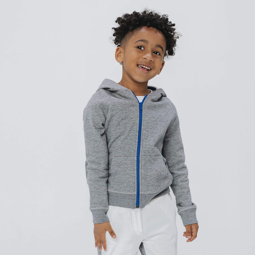 Boy wearing the Firebird Kids gray fleece zip hoodie with blue zipper