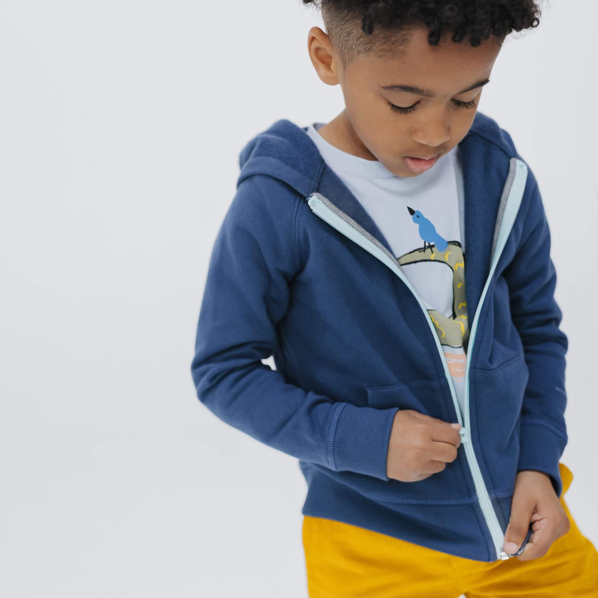 Boy wearing the Firebird Kids navy organic cotton fleece zip hoodie