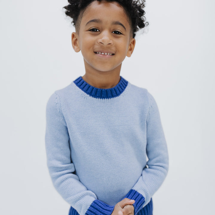 Kids colorblock crewneck sweater in light blue with cobalt contrast trim, organic cotton, knit in New York, front view on a boy