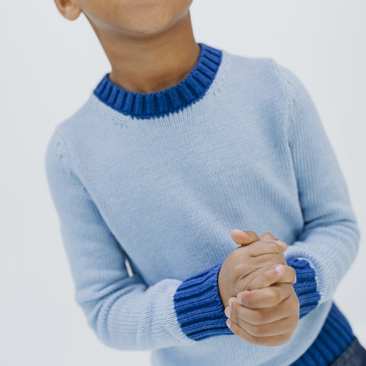 Cobalt ribbed crew neckline and cuffs on the light blue kids colorblock sweater