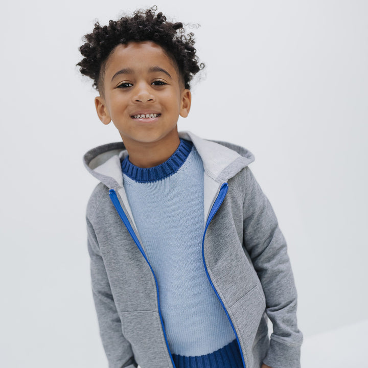 Light blue colorblock crewneck sweater layered under the Firebird Kids gray fleece zip hoodie