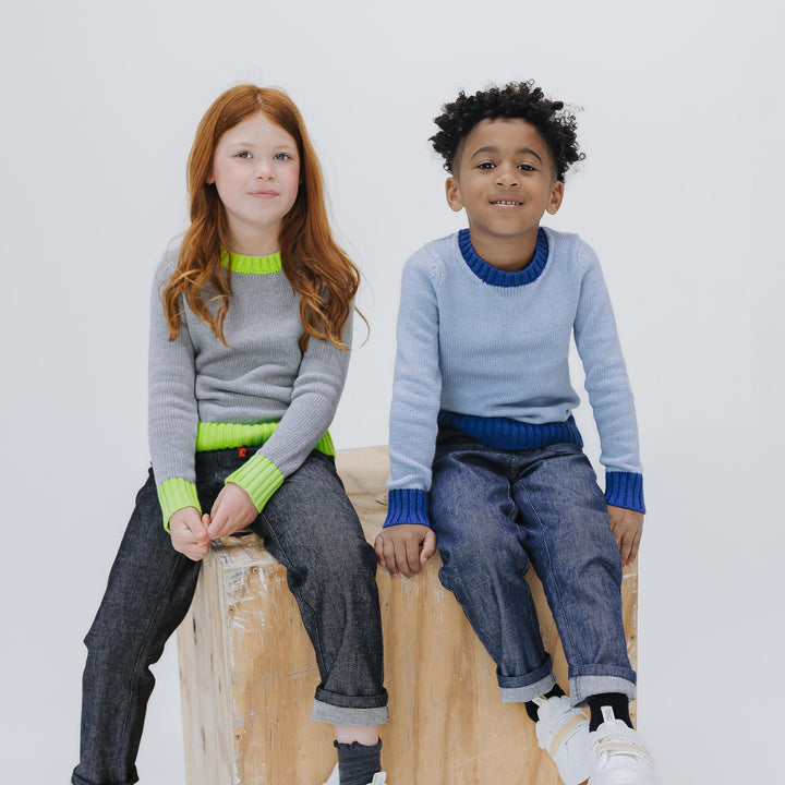 Girl in the heather grey colorblock crewneck sweater and boy in the light blue colorway, both with Firebird Kids denim pants