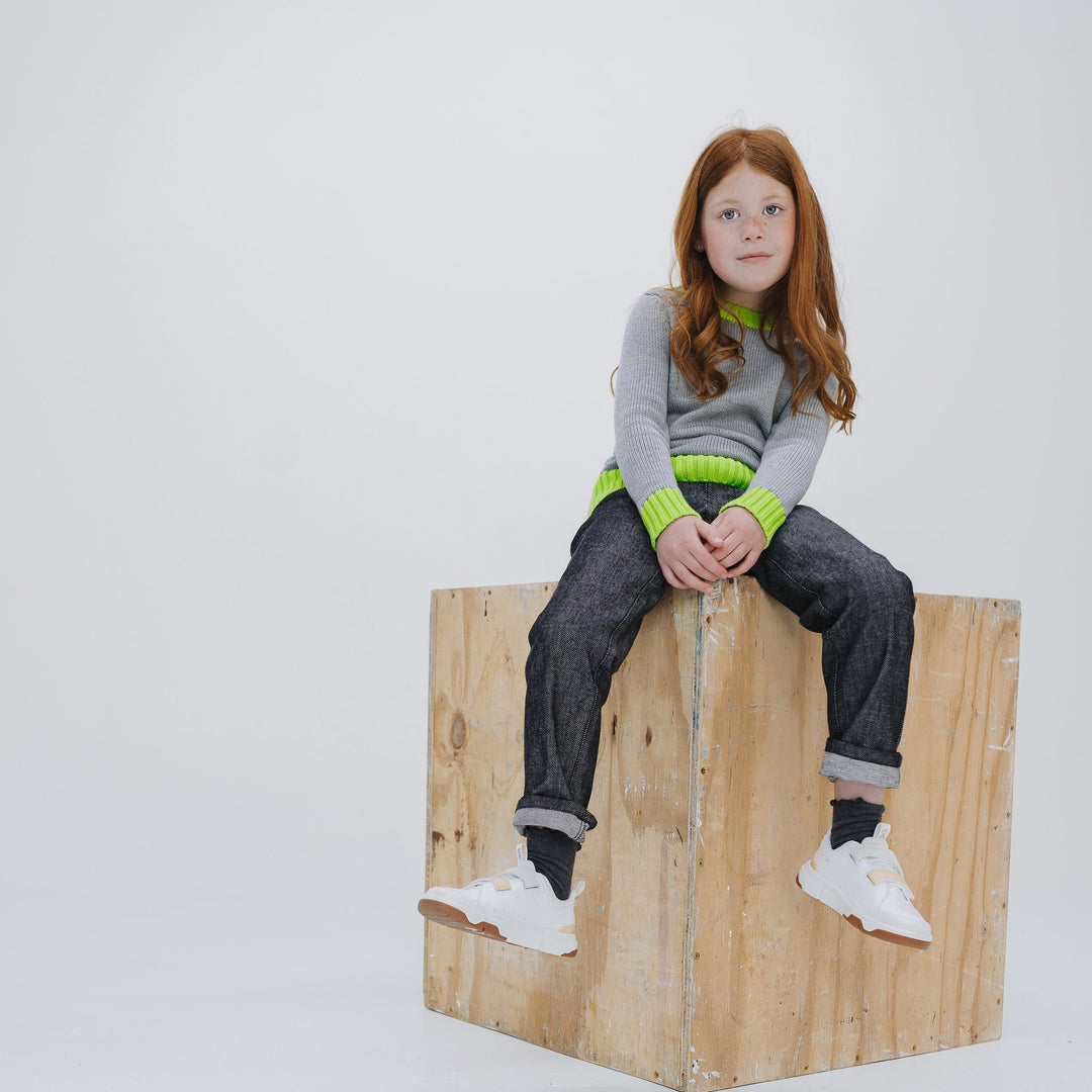 Girl wearing the heather grey colorblock crewneck sweater with Firebird Kids dark denim pants, full look