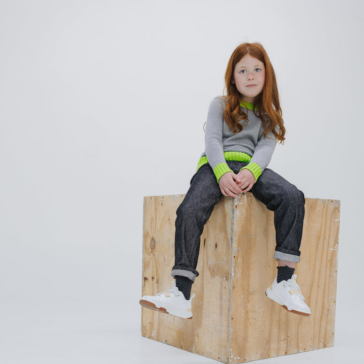 Girl wearing the heather grey colorblock crewneck sweater with Firebird Kids dark denim pants, full look