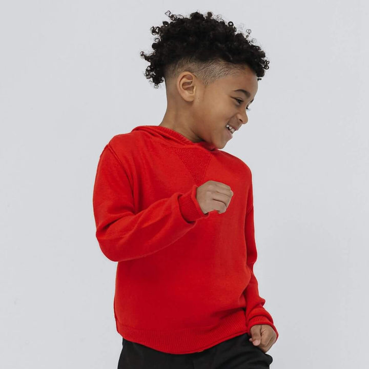 Boy wearing the Firebird Kids cotton cashmere hoodie sweater in bright red