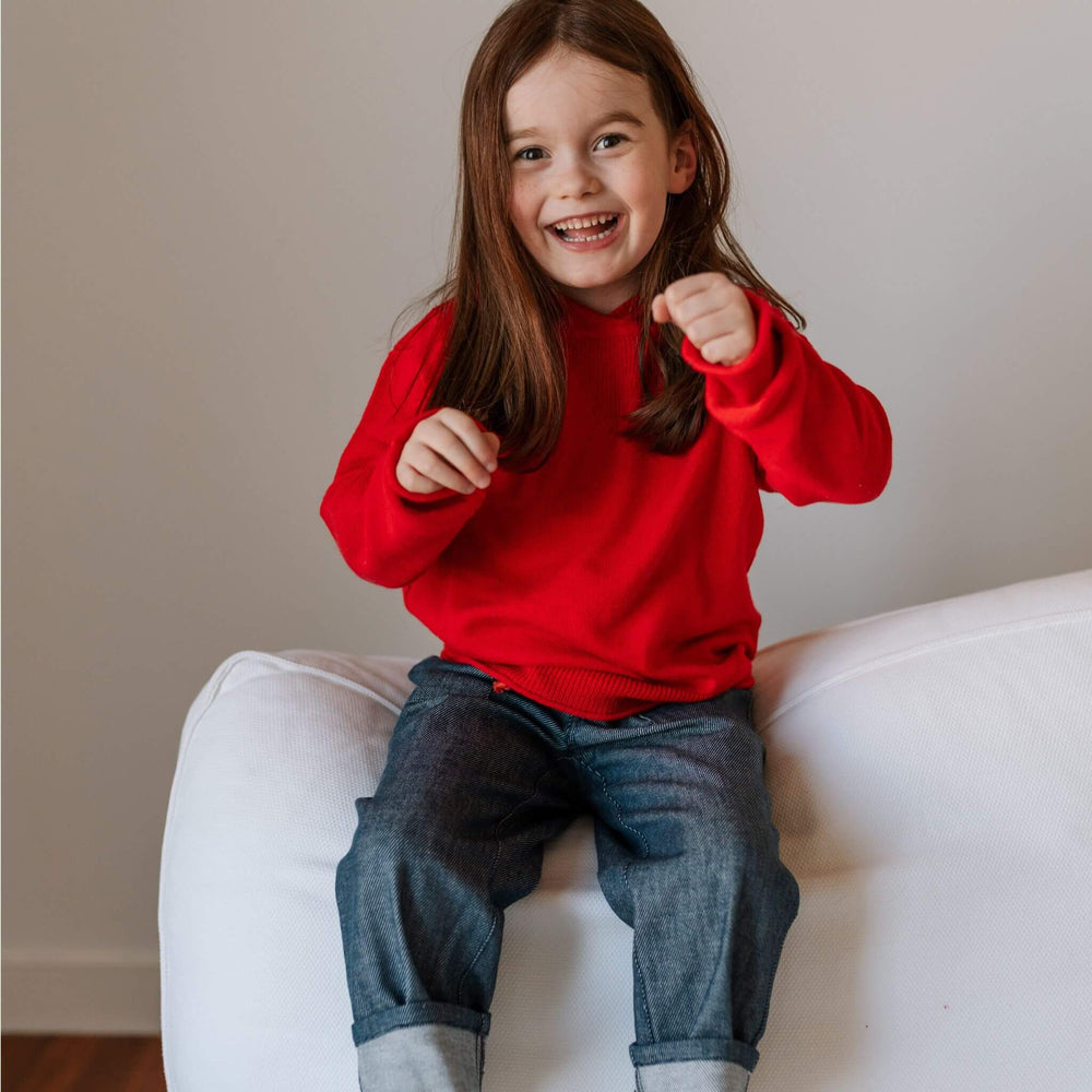 A girl wearing cotton cashmere blend sweater  hoodie in bright red