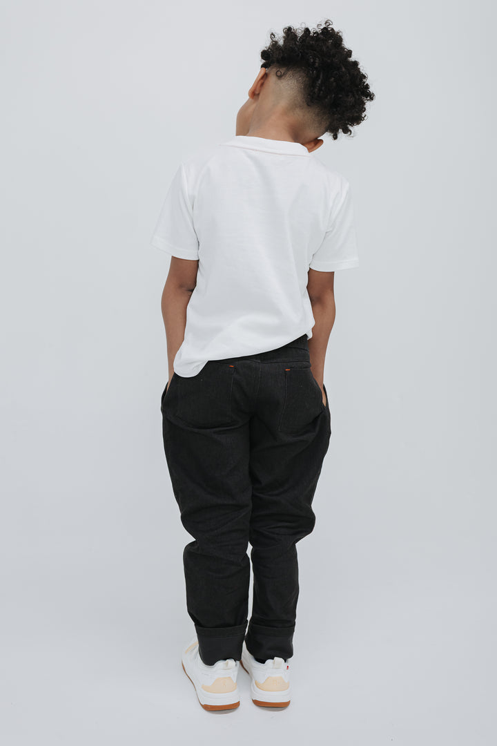 Back view of a boy in black drill pants showing the two back patch pockets