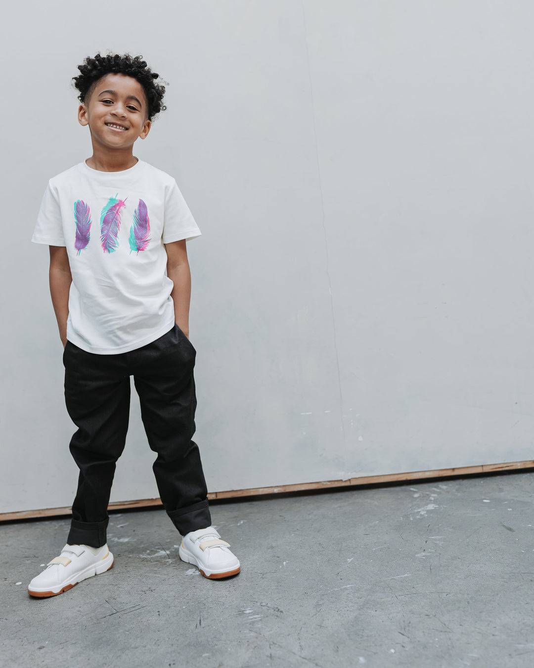 Boy wearing the Firebird Kids Vintage Drill Pant in black with a white graphic tee, full length front view