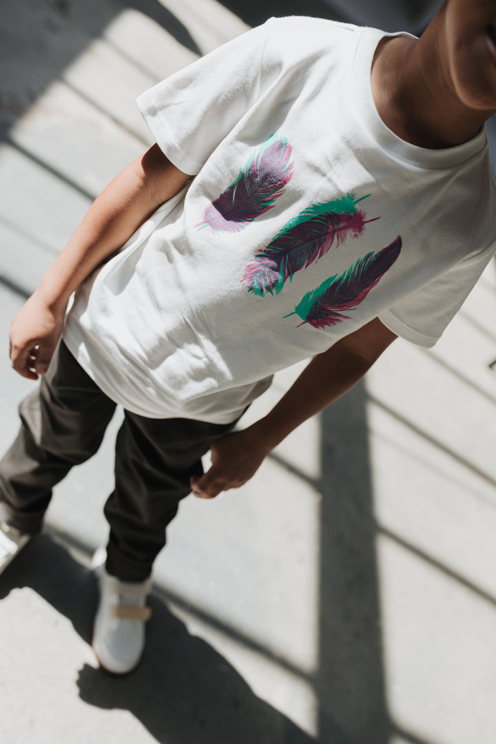 Boy walking through sunlight in black cotton twill pants