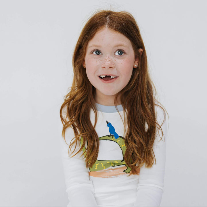 Girl wearing pajamas with a crocodile graphic print
