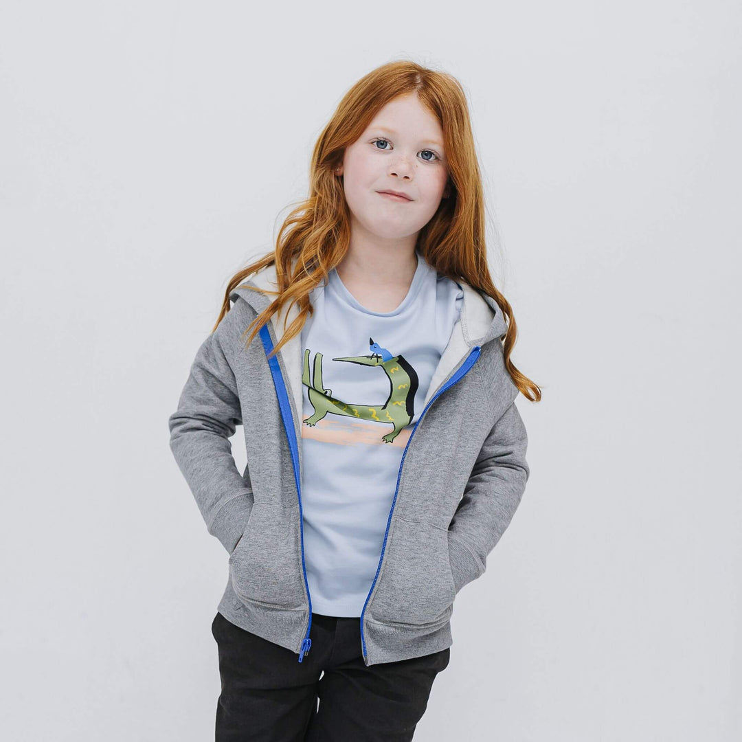 Girl wearing the Firebird Kids gray fleece zip hoodie with blue zipper and graphic tee