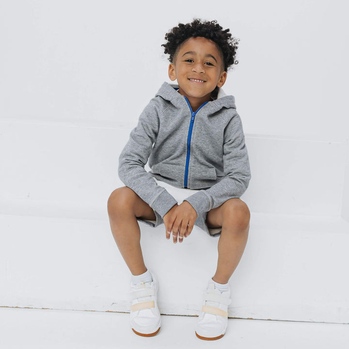 Child wearing the Firebird Kids heather gray organic cotton fleece zip hoodie