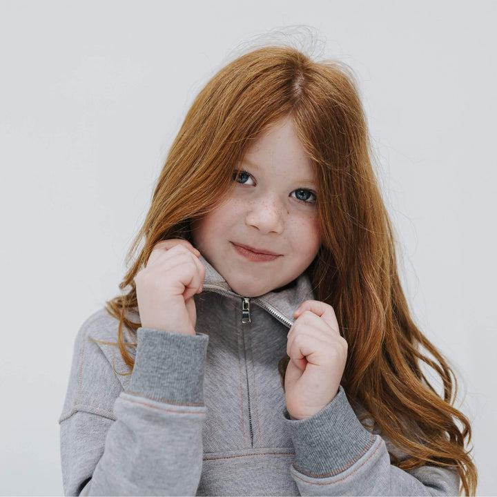 Girl wearing mockneck half zip sweatshirt 