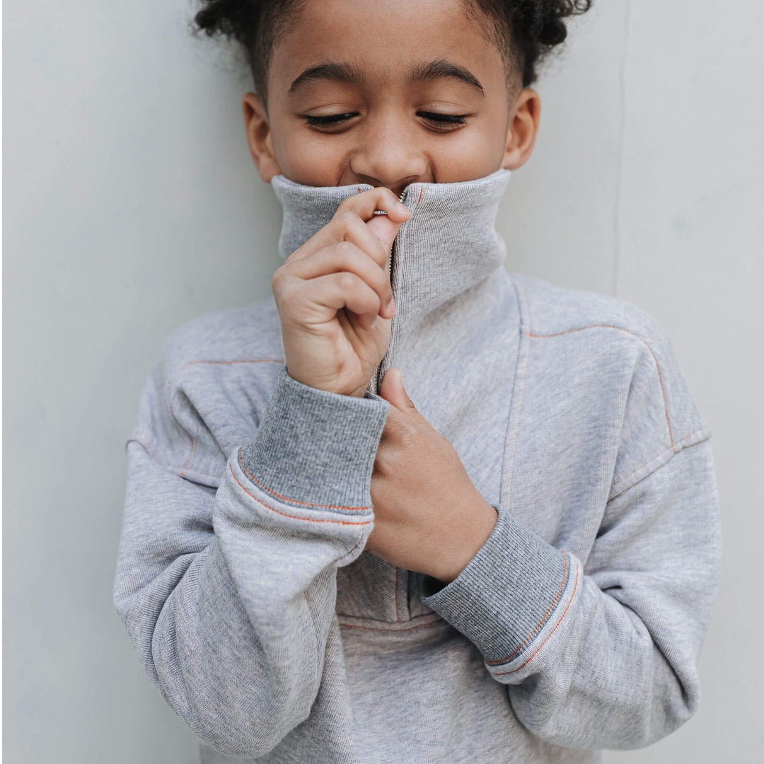 Close-up of the mockneck collar and zipper on the gray organic cotton half-zip sweatshirt