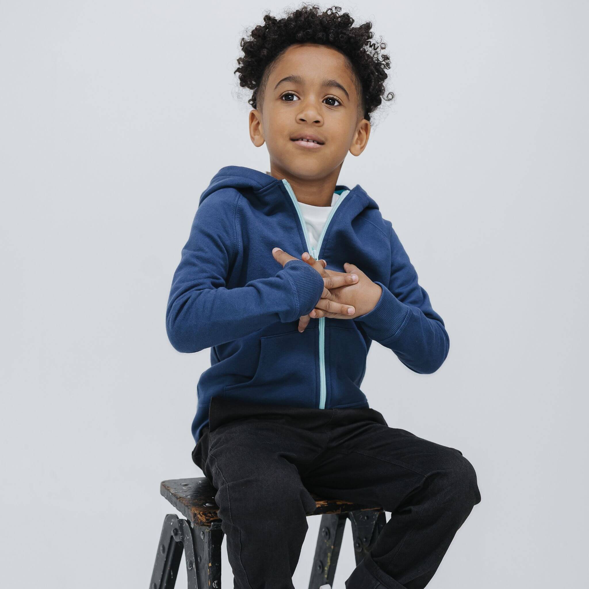 Child wearing the Firebird Kids navy organic cotton fleece zip-up hoodie