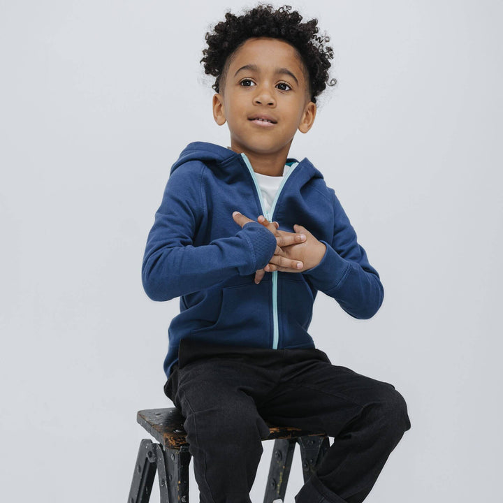 Child wearing the Firebird Kids navy organic cotton fleece zip-up hoodie