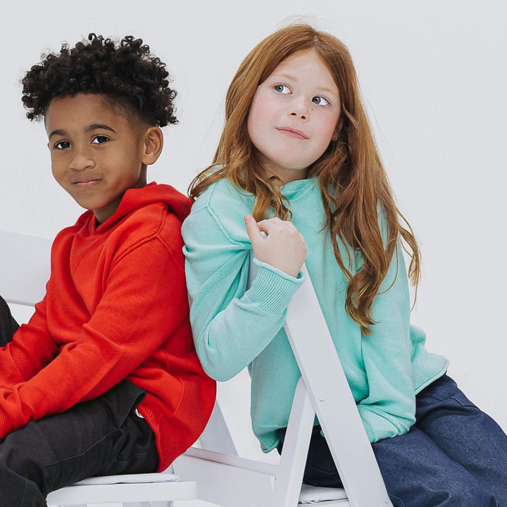 Boy and girl wearing cotton cashmere hoodie sweaters in red and light blue 