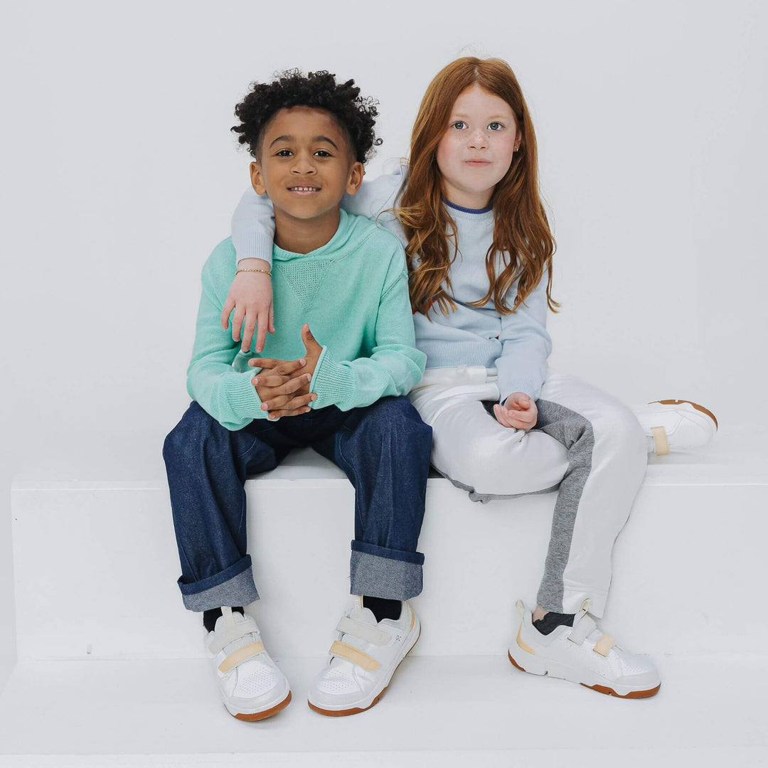 Two kids wearing sweaters. Boy wearing blue cotton cashmere hoodie 