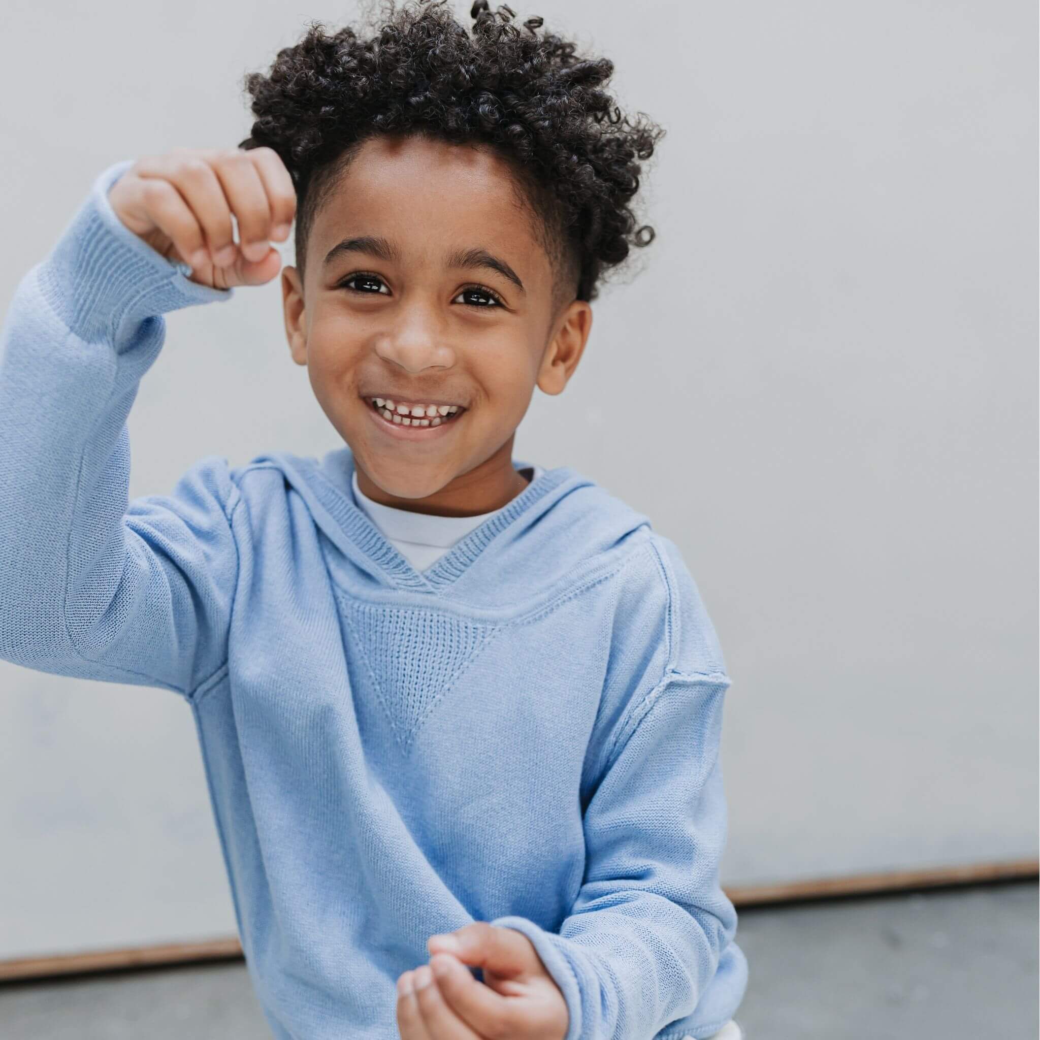 A child wearing the Firebird Kids light blue cotton-cashmere hoodie sweater