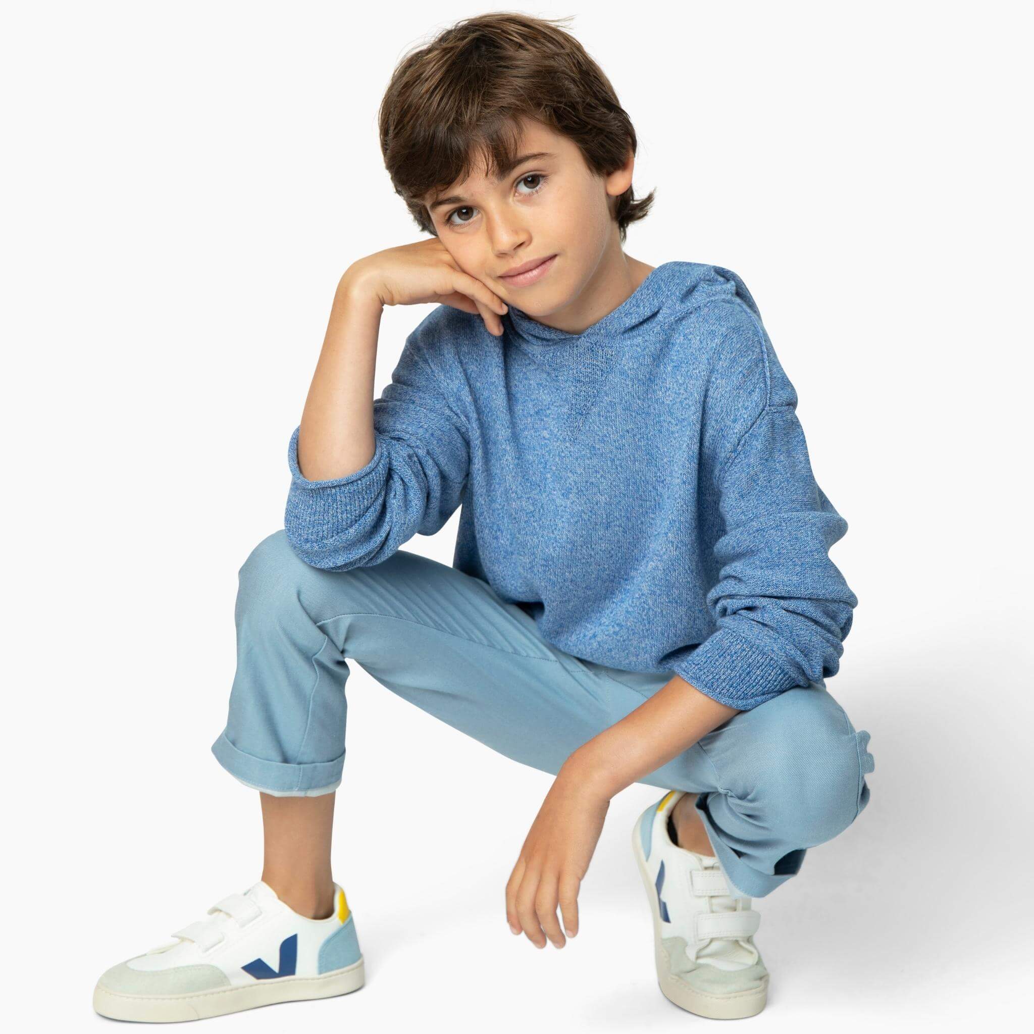 Boy wearing light blue soft denim pants and one of our best boys sweaters from our Kids Essentials organic cotton collection. 