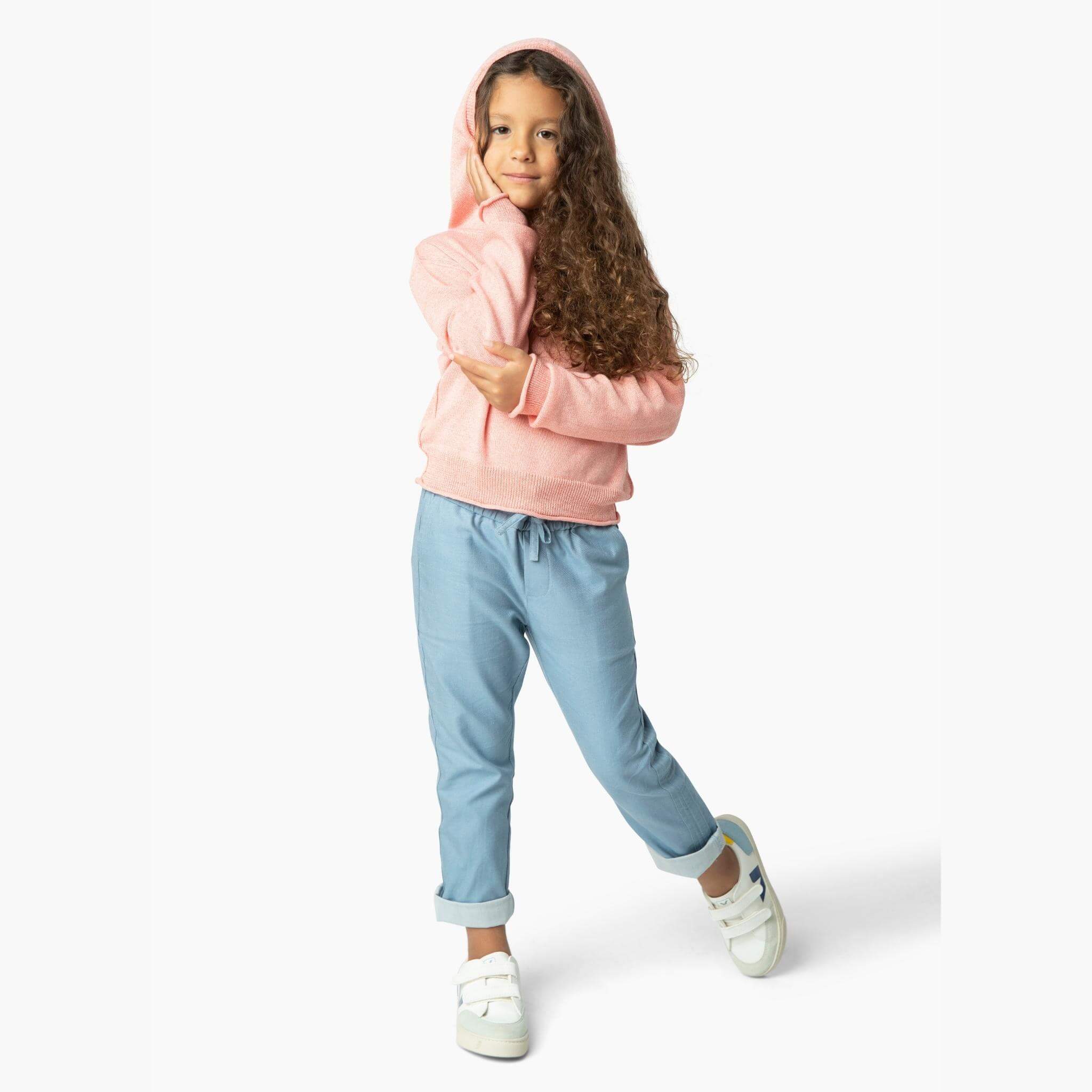 Girl wearing light blue soft denim pants and one of our favorite kids sweaters from our Kids Essentials organic cotton collection.